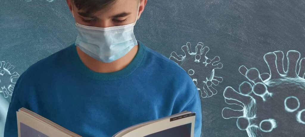 Foto eines lesenden jungen Mannes mit Mundschutz