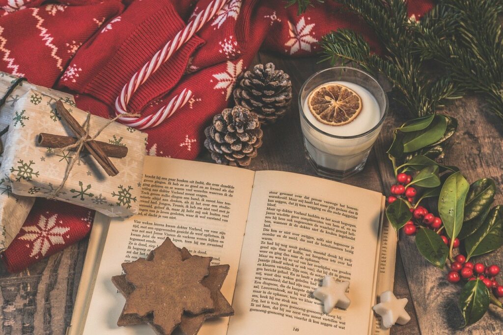 Weihnachtsdekoration mit Buch, Kerze, Geschenken und Plätzchen