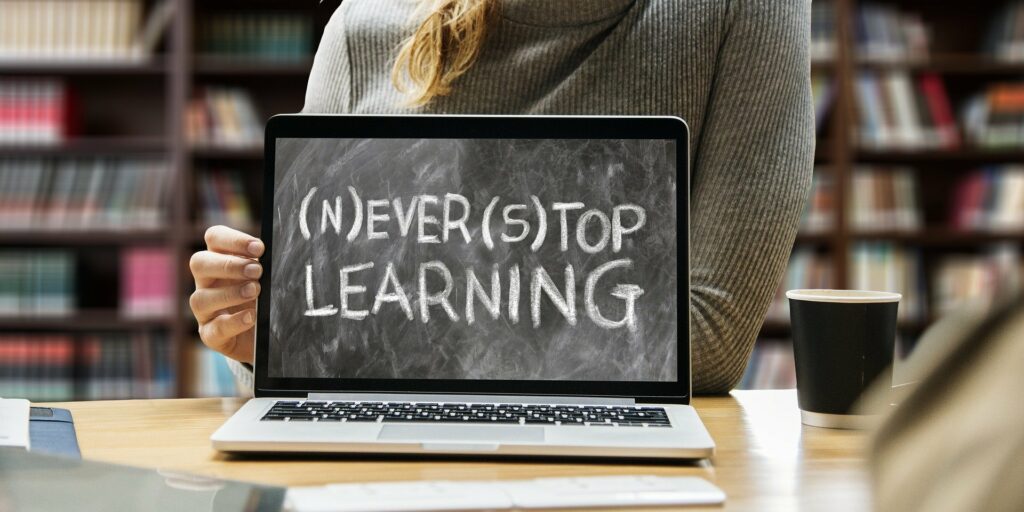 Foto eines Laptops mit der Bildanzeige "(N)ever (S)top Learning